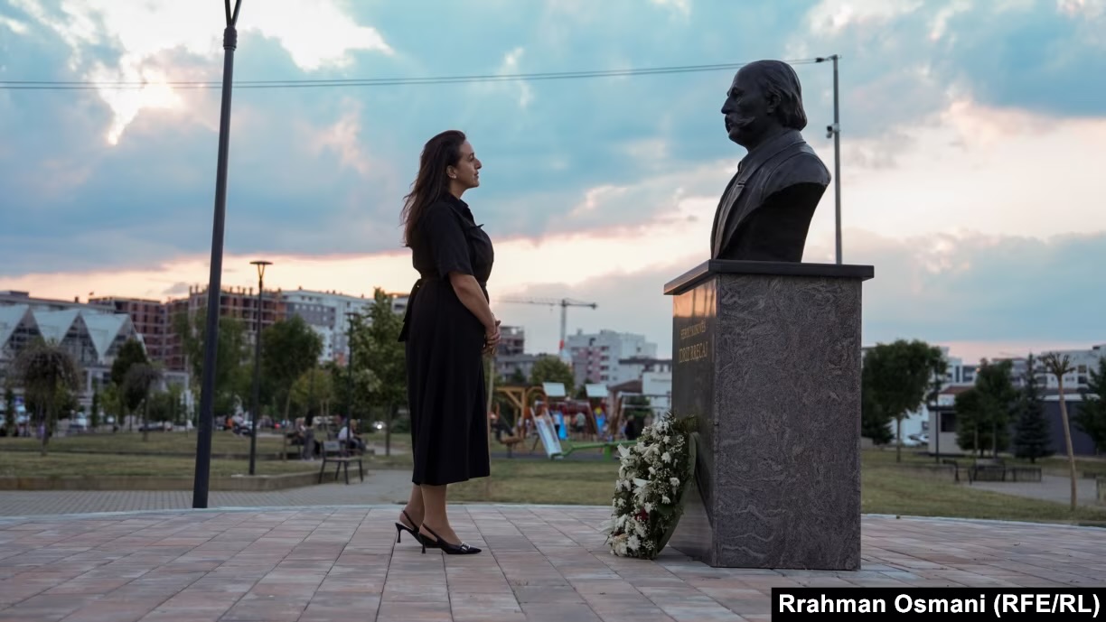 Flora Rrecaj pranë bustit të babait të saj, Idriz Rrecaj