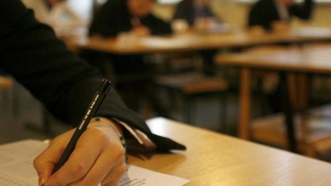 Kandidat duke plotësuar testin e maturës në klasë