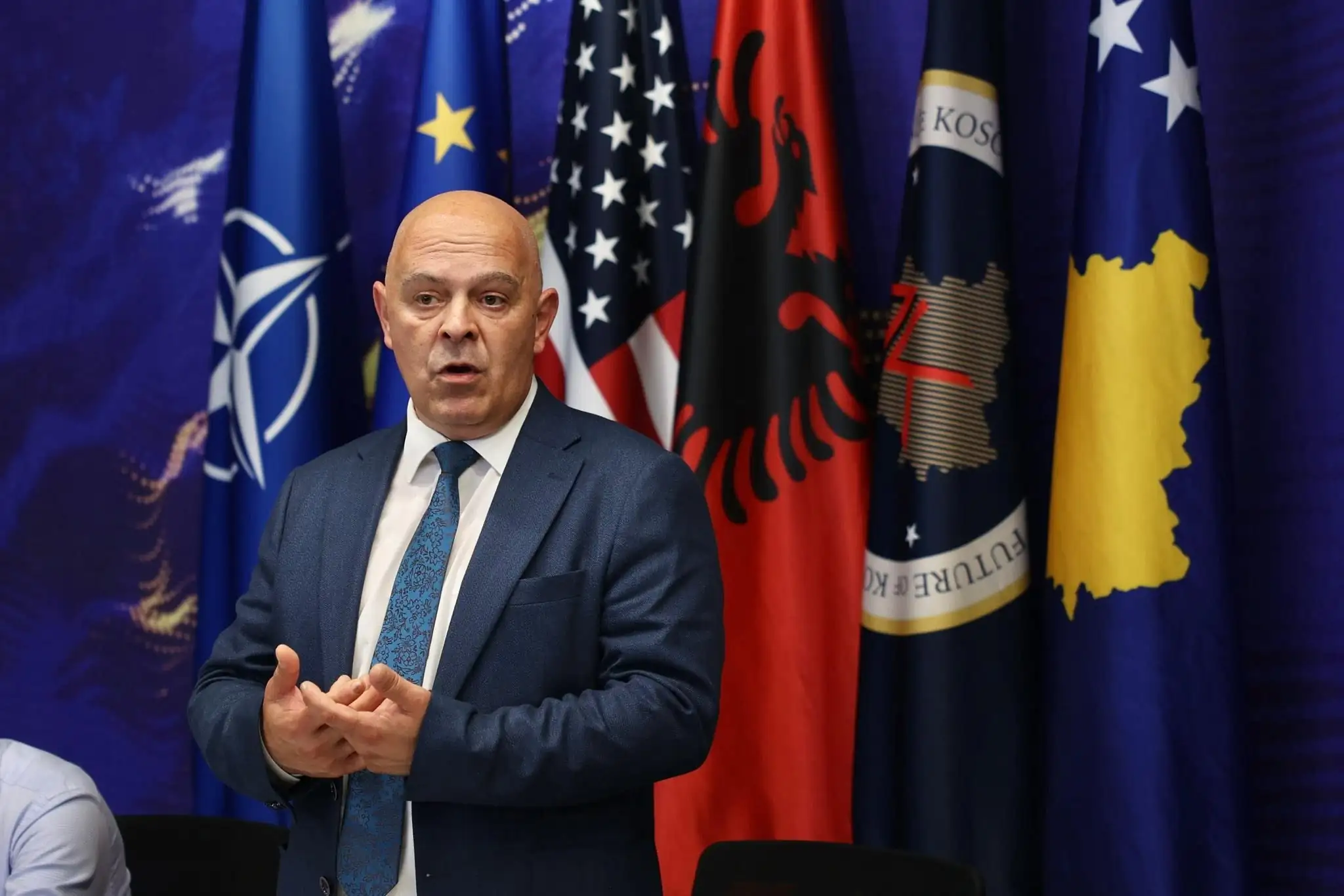 Ardian Gjini para flamujve të Kosovës dhe NATO-s